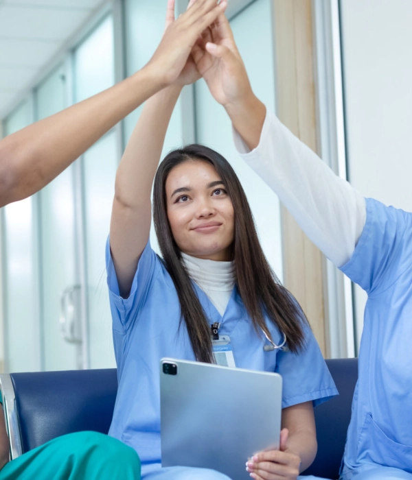 Three nursing students raising their hands together